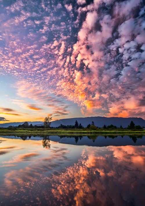 paesaggio con cielo al tramonto con un lago con riflessi nell'acqua 
