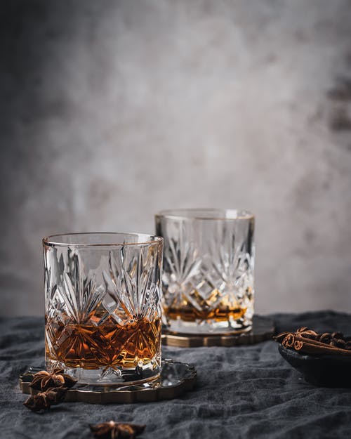 bicchieri con versato al loro interno del whisky 